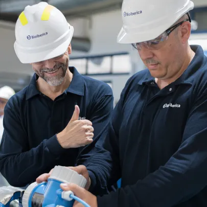 Trabajadores con cascos de seguridad en instalaciones de producción industrial